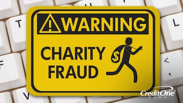 A warning sign stating, “charity fraud” rests on top of a keyboard.