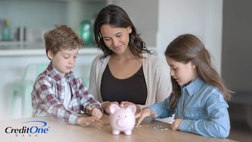 A young mom and her two children sit at the kitchen table counting money from their piggy bank, which is an early step to teaching kids about building credit.