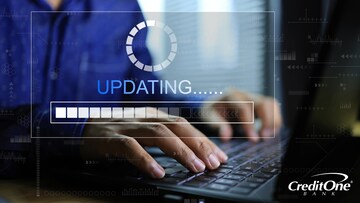 Two hands rest on a laptop’s keyboard behind an overlay of the word “Updating” and a progress bar. Perhaps this person is watching as their credit score updates on the screen.