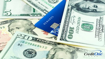 A credit card marked “rewards” sits in a pile of USD bills, representing how you can maximize your credit card rewards.