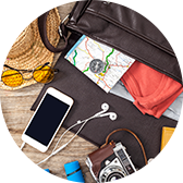 A travel bag with a phone, a camera, a map and other travel items coming out of it